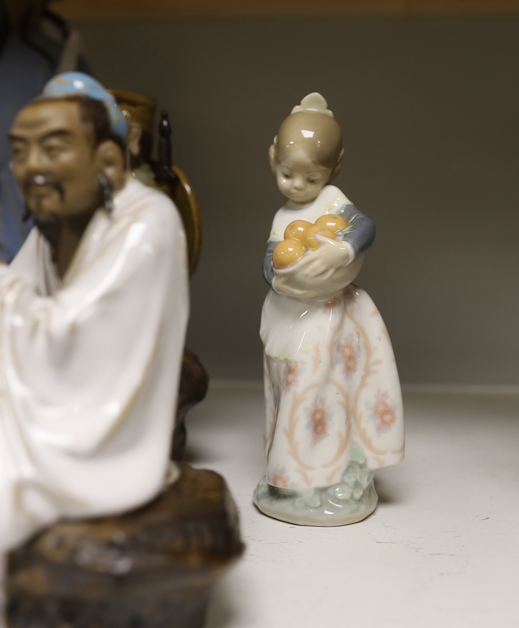 A group of Chinese Shiwan stoneware figures, a composition triptych shrine and a Lladro figure, tallest 33cm high